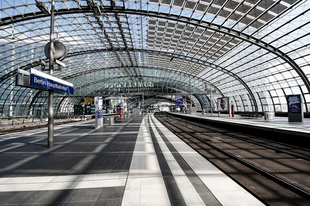 The glass hall of Berlin central station, with empty platforms and the Berlin Hauptbahnhof sign